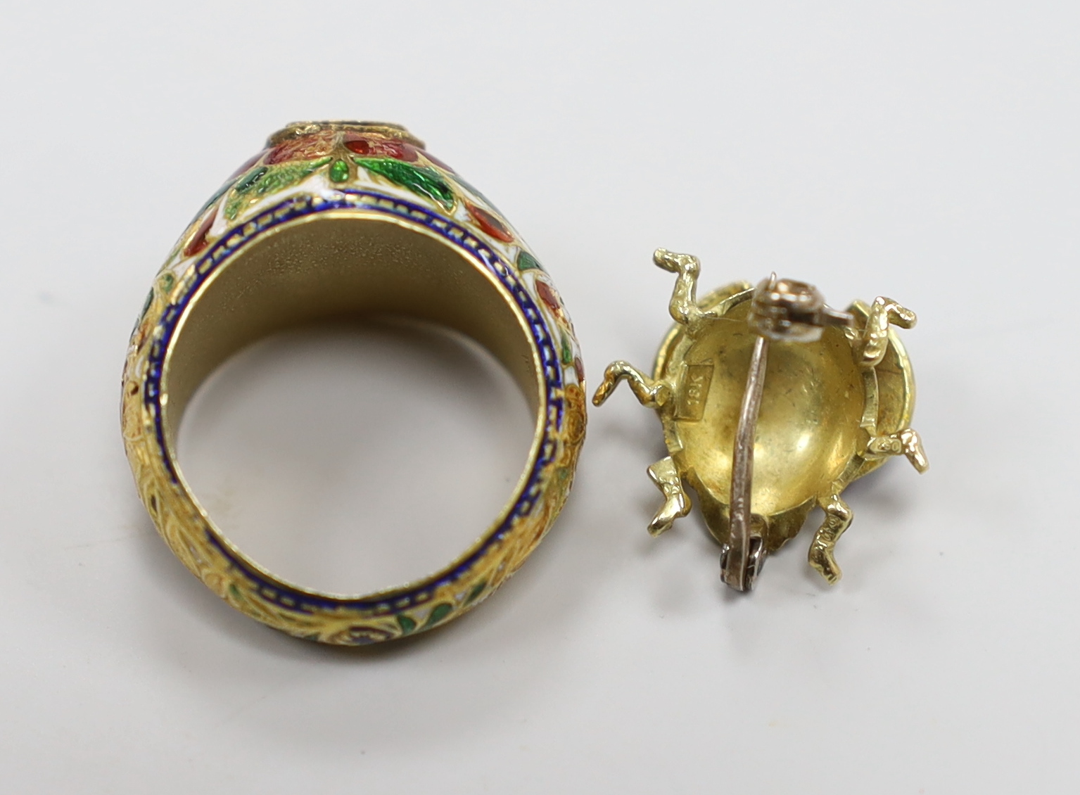 A modern 18ct gold and three colour enamel set small bug brooch, 13mm, gross weight 3.1 grams and an Indian yellow metal, diamond and enamel set dress ring, gross weight 6 grams.